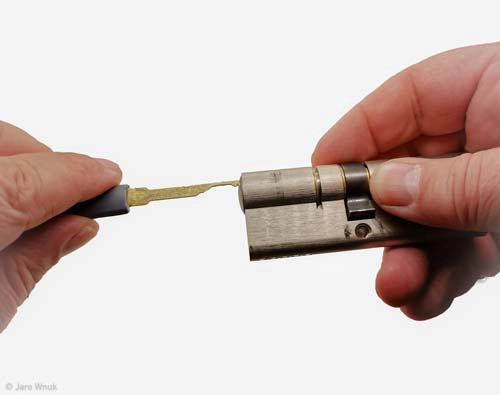 Hände mit Pick-Werkzeug an einem ausgebauten Schließzylinder